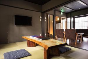 een woonkamer met een houten tafel en een televisie bij Reikaku Yasaka in Kyoto