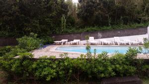 einen Pool mit Liegestühlen und einem Pool in der Unterkunft Casal do Vulcão in Capelo