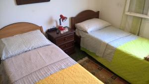 Diano San PietroにあるBella liguriaのベッドルーム1室(ベッド2台、ランプ付きドレッサー付)