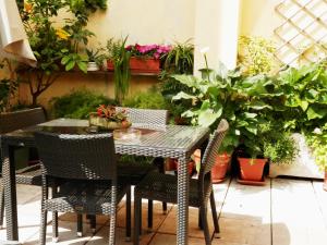 ヴェローナにあるCasa Ferrari Appartamento Verona Sanificato Ozonoの鉢植えの植物が植えられたパティオ(テーブル、椅子付)