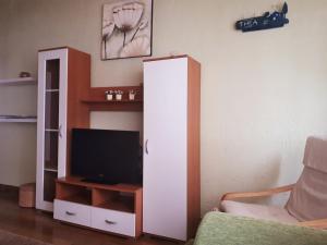 a living room with a tv and a white cabinet at Apartman Thea Gomirje in Gomirje