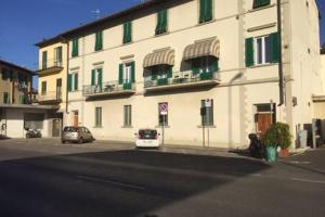 un grand bâtiment blanc avec des voitures garées devant lui dans l'établissement Il Podesta, à Florence
