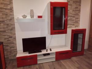 a living room with a tv and red cabinets at Apartments Rajka in Lopar