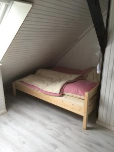 a wooden bed in a room with a attic at Hof Larina in Schleswig