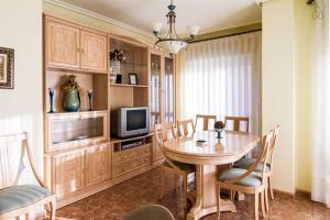 ein Esszimmer mit Tisch und Fernseher in der Unterkunft RUMOHOLIDAYS Spacious 3 bedrooms apartment Playa del Cura in Torrevieja