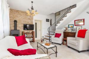 a living room with a white couch and red pillows at HIDDEN PARADISE - Villa by Split in Žrnovnica