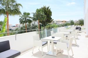 una fila de mesas y sillas en un balcón con palmeras en Vila Petra en Albufeira