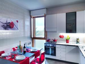 uma cozinha com uma mesa e cadeiras vermelhas numa cozinha em Residenza Bellaria Park "Hills View" em San Lazzaro di Savena