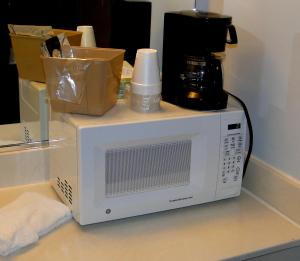 a white microwave sitting on top of a counter at Sea Esta Motel II in Long Neck