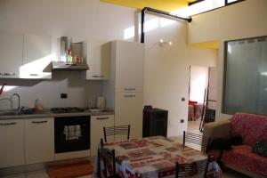 a kitchen with a table and a stove and a kitchen with a table at Scirocco dal Mare in Fano
