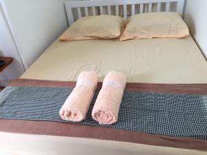 dos toallas enrolladas sentadas en una cama en Siriwal Guesthouse, en Phra Nakhon Si Ayutthaya