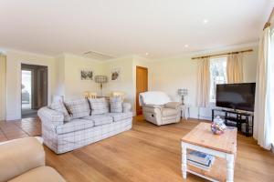 a living room with two couches and a flat screen tv at Riverview Retreat in Perth