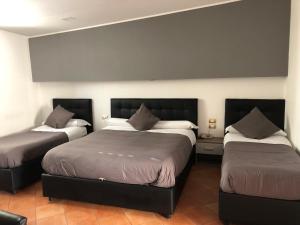 two beds in a room with two bedsskirts at Hotel Nettuno in Naples