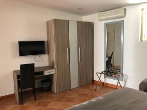 1 dormitorio con un gran armario de madera y TV en Hotel Nettuno, en Nápoles