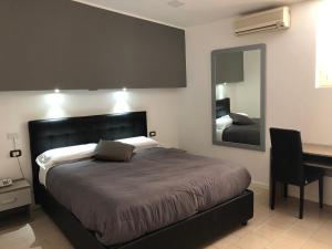 1 dormitorio con cama, escritorio y espejo en Hotel Nettuno, en Nápoles