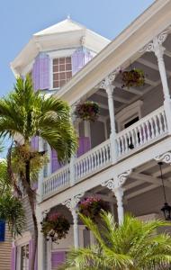 une maison blanche avec une véranda et un palmier dans l'établissement The Artist House, à Key West