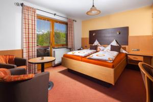 ein Hotelzimmer mit einem Bett, einem Stuhl und einem Tisch in der Unterkunft Pension Elvira in Bischofswiesen