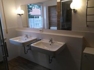 ein Badezimmer mit 2 Waschbecken und einem Spiegel in der Unterkunft Appartement in Planegg
