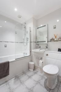Baño blanco con aseo y lavamanos en Riverview Retreat en Perth