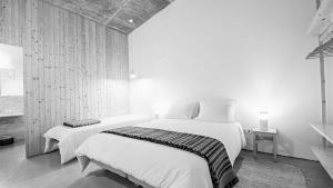 a black and white photo of a bedroom with two beds at Casa do Roxo - Eco Design Country House in Santa Vitória