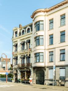 een groot gebouw op de hoek van een straat bij Hotel Des Ardennes in Verviers