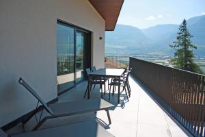 een balkon met een tafel en stoelen erop bij Tholr - Ferienwohnungen - Tramin in Termeno