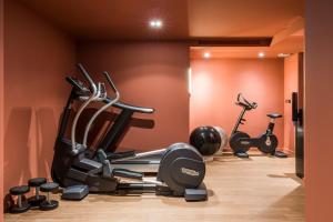 een fitnessruimte met diverse hometrainers in een kamer bij Grand Powers Hotel in Parijs