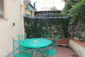 a green table and chairs on a patio at Gmax Guelfa Apartments in Florence
