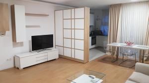 uma sala de estar com televisão num armário e uma mesa em Top Trio Residence em Bucareste