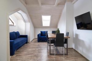 a dining room with a blue couch and a table at Villa Gor Apartments in Bukovel
