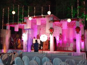 a wedding stage with pink lights and a group of people at Hotel Mangal Residency Lonavala - Best Hotel in Lonavala in Lonavala