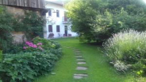 un jardín con un camino de piedra frente a una casa en B&B Castellani, en Fanna