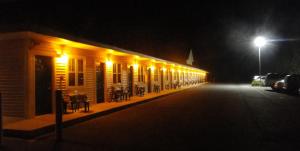 an empty street at night with a row of buildings at Sea Esta Motel II in Long Neck