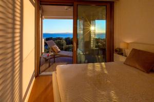 a bedroom with a bed and a balcony with a view at Bel Etage Amora Luxury Seaview Apartment with pool in Split