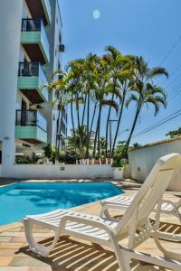 un par de sillones junto a una piscina en Orange Beach Enseada Guarujá - Piscina, Ar, Wi-Fi, 3 Quartos a Poucos Passos do Mar, en Guarujá
