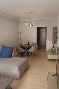 a bedroom with a bed and a dining room at Stylish Zoi's appartment next to HELEXPO, White Tower in Thessaloniki