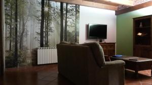 a living room with a couch and a flat screen tv at Casa Aldea in Griegos