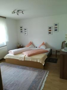 um quarto com uma cama com almofadas cor-de-rosa em Ferienwohnung "Wißbergblick" em Wolfsheim