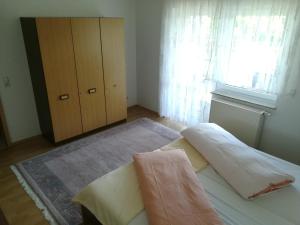 um quarto com uma cama, uma cómoda e uma janela em Ferienwohnung "Wißbergblick" em Wolfsheim