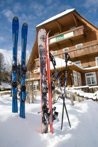 un grupo de esquís y postes en la nieve frente a un lodge en Hotel Adler Bärental, en Feldberg