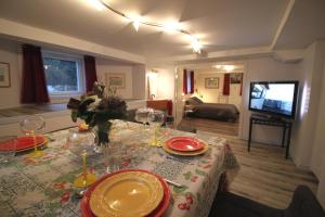 una sala de estar con una mesa con platos y copas de vino en Confort et calme à Colmar en Colmar