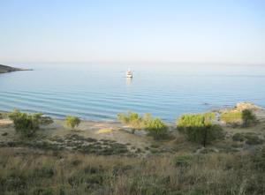 a boat in the middle of a large body of water at Ariston Apartments in Serifos Chora