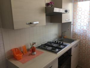 una piccola cucina con piano cottura e lavandino di App sul lungomare a San Benedetto del Tronto