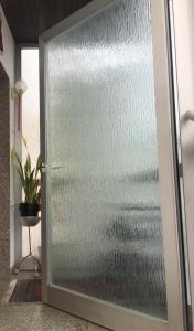 a glass door in a room with a plant at RELAX APPARTEMENT - Graz in Graz