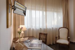 カストリニャーノ・デル・カーポにあるラ キオッチョオラのテーブルと椅子、窓が備わる客室です。