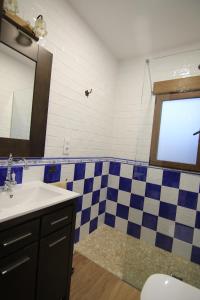 a bathroom with a sink and a checkered wall at EL MIRADOR DEL MOLINO in Ossa de Montiel