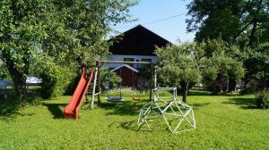 um parque infantil num quintal com um escorrega e um baloiço em Ferienwohnung auf einem richtigen Bauernhof em Finkenstein