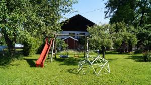 un parco giochi in un cortile con scivolo e altalena di Ferienwohnung auf einem richtigen Bauernhof a Finkenstein am Faaker See