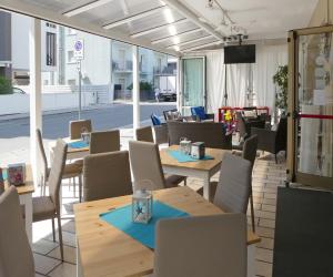 um restaurante com mesas e cadeiras de madeira e uma rua em Hotel Saturno em Lido di Jesolo