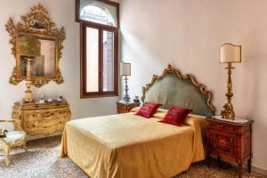 a bedroom with a bed with two red pillows on it at Luxury Venetian Rooms in Venice